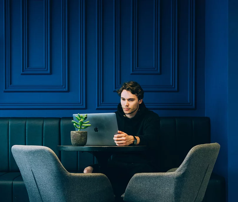 a man sitting with a laptop